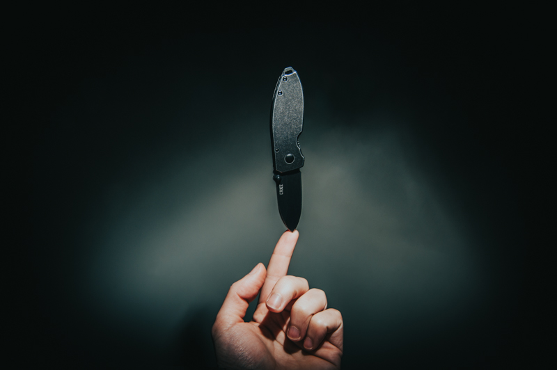 A knife balancing on someone's finger by it's sharp point