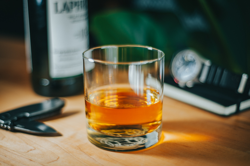 A close-up of a glass of whiskey, highlighting the color and texture of the drink