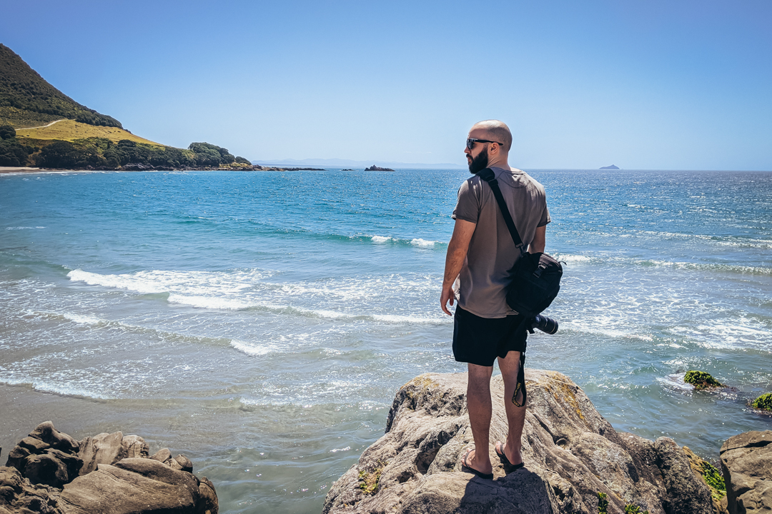 Taylor Verde standing by the ocean with his camera